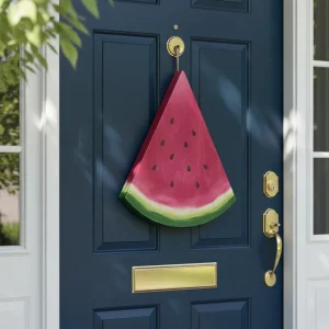 A professional DIY wood watermelon door hanger on a navy blue front door for summer curb appeal.